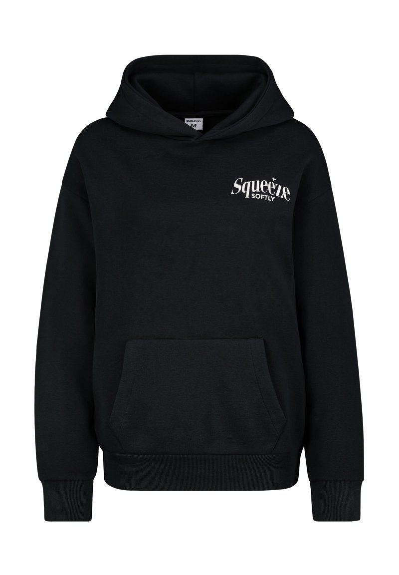 Schwarzer Baumwoll-Hoodie mit einer vorderen Kängurutasche. Mit einem weißen Logo, das "Squeeze Softly" auf der oberen linken Brust liest. Klassische Passform.