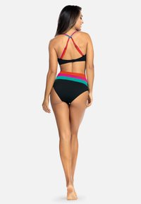 Czarna górna część bikini z kolorowymi ramiączkami; dolna część z wysokim stanem ma poziome paski w kolorach czerwonym, pomarańczowym, zielonym i czarnym. Gładka struktura.