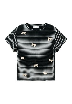 Camicia a maniche corte a righe bianche e nere con piccole applicazioni a fiocco bianche sparse sul davanti.