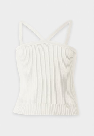 Λευκό ριμπ πλεκτό crop top με λεπτές τιράντες και μια μικρή μεταλλική ετικέτα κοντά στο κάτω μέρος.