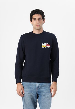Mornarica bombažna majica s kavljem in ovratnikom. Ima večbarvni logotip "Tommy Hilfiger" na prsih. Klasična prileganje.