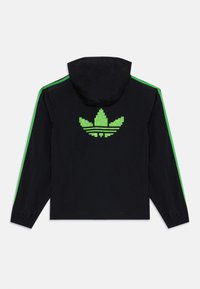 Čierna bunda s kapucňou, na zadnej strane s pixelovaným zeleným logom, so zelenými bočnými pruhmi, vyrobená z ľahkého materiálu a s elastickými manžetami.