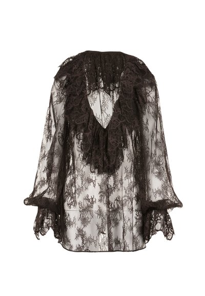 Blusa di pizzo nero con scollatura a V arricciata, maniche ampie e intricati motivi floreali. Semi-trasparente con dettagli in rilievo.