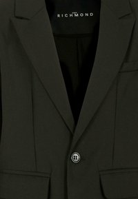 Ciemnozielona marynarka z teksturowanej tkaniny, zapięcie na jeden guzik, klapy z wcięciami oraz dwie przednie kieszenie. Podszewka wewnętrzna.