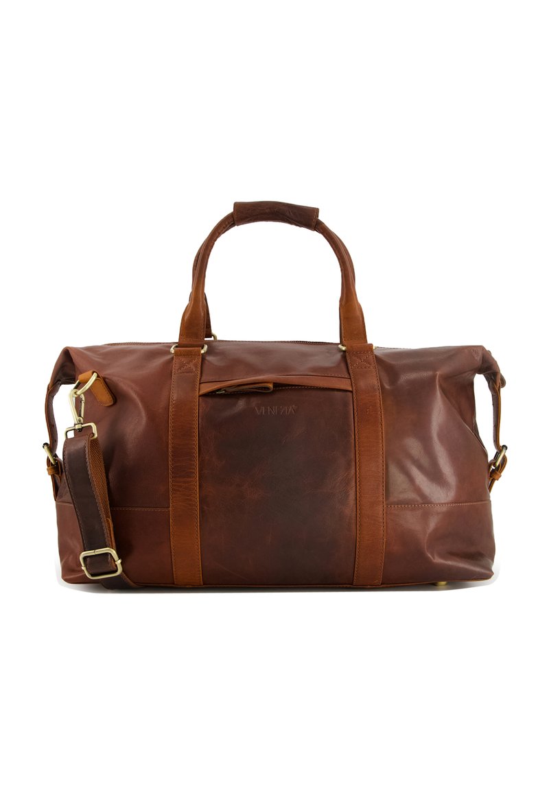 Sac de voyage en cuir brun avec des finitions dorées, doté de poignées supérieures doubles, d'une bandoulière amovible et d'une surface lisse et texturée.