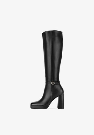 Stivale alto in pelle nera con tacco, punta arrotondata, suola con plateau e un piccolo cinturino alla caviglia con fibbia argentata.