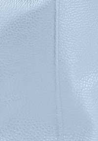 Cuir bleu clair texturé avec un motif à grain fin. Détail de couture le long du bord, mettant en valeur une finition lisse et une apparence douce.