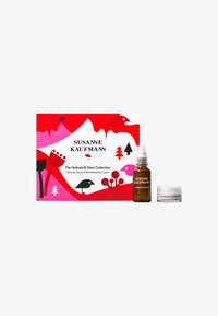 Serum hialuronowy i odżywczy krem na dzień w przezroczystej butelce i białym słoiczku, wyeksponowane na tle wyrazistego, czerwono-różowego pudełka w wzory.