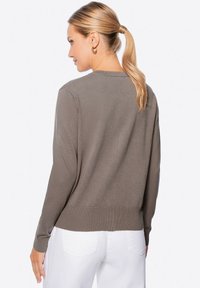 Grauer Strickpullover mit Rundhalsausschnitt, langen Ärmeln und geripptem Saum. Das Material wirkt weich und leicht.