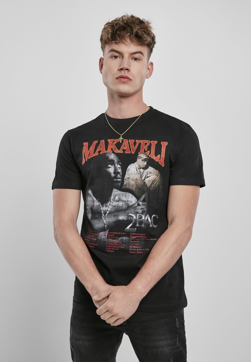 Czarna bawełniana koszulka z grafiką Tupaca Shakura, z napisem "MAKAVELI" na czerwono powyżej i tytułami utworów wymienionymi poniżej.