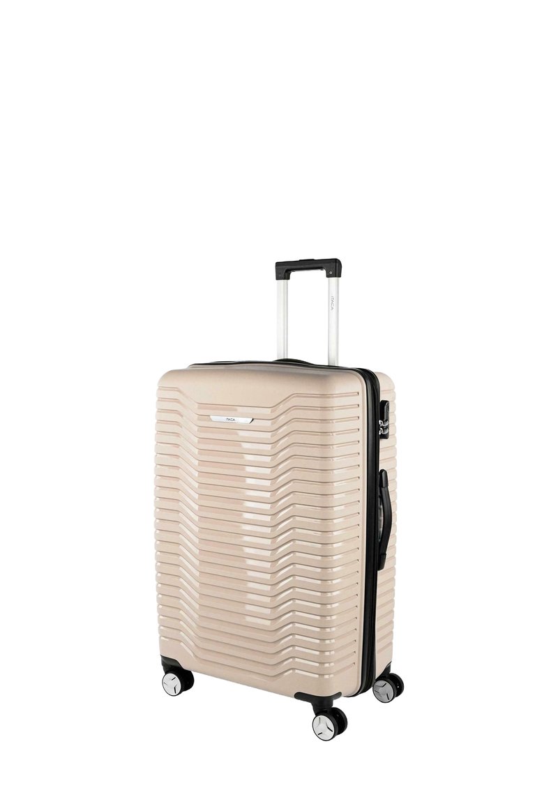 Maleta rígida de tamaño mediano en color beige con diseño acanalado, asa retráctil, cuatro ruedas y cremallera negra. Cuenta con un asa lateral.