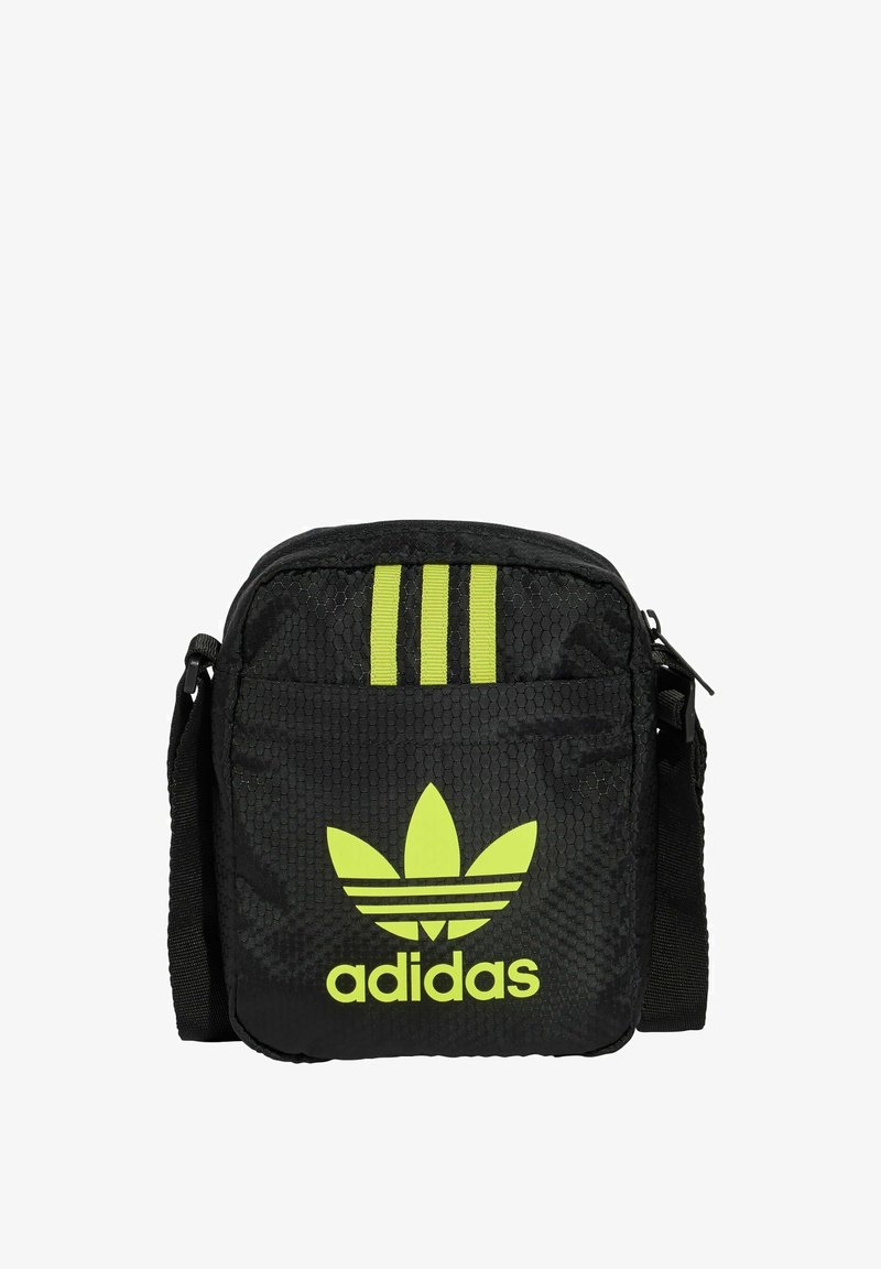 Borsa a tracolla in tessuto nero con trama a nido d'ape, dettagli a tre strisce verdi e un grande logo Adidas verde sulla parte anteriore.