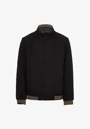 Schwarze Jacke mit Stehkragen, elastischen Bündchen und geripptem Saum, die goldene und weiße Streifen zeigt. Glattes Material ohne sichtbare Muster.