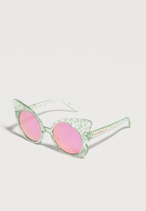 Gafas de sol estilo ojo de gato con montura translúcida verde con purpurina y lentes redondas espejadas en rosa sobre fondo blanco.