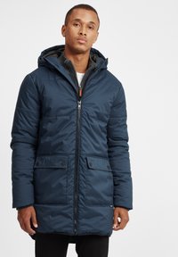 Parka albastră închis, izolată, cu glugă, fermoar frontal, două buzunare laterale și un căptușeală texturată. Dispune de un design casual.