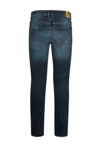 Jeans de mezclilla azul oscuro mostrados desde la parte trasera con dos bolsillos traseros, pasadores para cinturón y una etiqueta de marca marrón en la cintura.