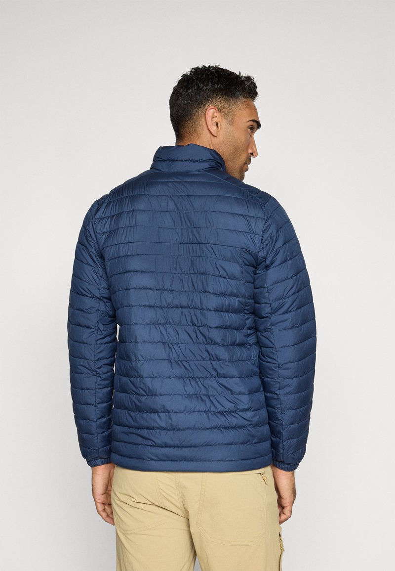 Veste matelassée bleu marine, avec un col haut et un design léger. Surface texturée avec des coutures horizontales, des coutures visibles et des poignets élastiques.