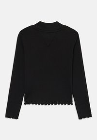Svart langermet ribbet topp med høy krage og lett bølget detalj på ermene og bunnkanten, lagt flatt på hvit bakgrunn.