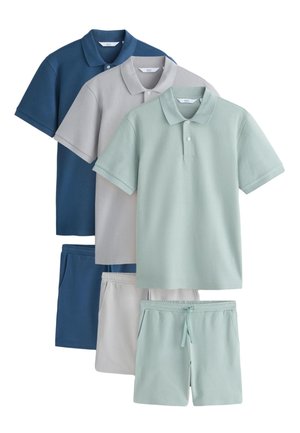 Tre sæt poloer og matchende shorts i blå, grå og lysegrøn, arrangeret overlappende mod en hvid baggrund.