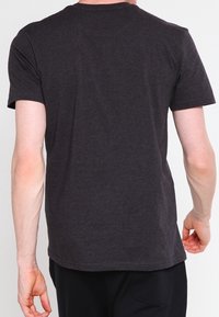 T-shirt z krótkim rękawem, okrągłym dekoltem w ciemnoszarym kolorze z bawełny. Posiada regularny krój, gładką teksturę, czyste szwy i brak widocznych logo.