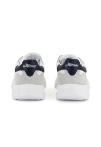 Sneaker bianche e grigie con un design in suede e rete, dotate di una robusta suola bianca e un accento sul tallone blu navy con il logo.