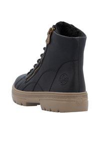 Bottine en cuir noir avec une surface texturée, fermeture éclair en métal et une semelle en caoutchouc beige. Présente un logo sur le côté.