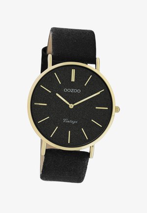 Montre OOZOO avec un cadran texturé noir, des index d'heure dorés et des aiguilles dorées, montée sur un bracelet en suede noir. Présente un design minimaliste.
