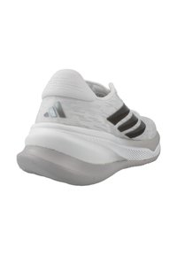 Baskets blanches avec un dessus en tricot texturé, trois bandes noires, une semelle intermédiaire grise rembourrée et une semelle extérieure grise lisse.