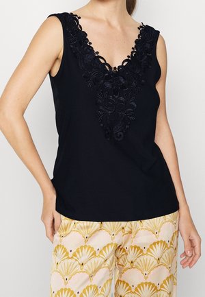 Zwarte mouwloze top met een diepe V-hals en sierlijke zwarte kant borduursel bij de halslijn; gladde stof met een ontspannen pasvorm.