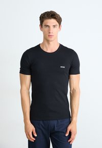 T-shirt noir à manches courtes en coton, avec un col rond et un petit logo blanc "BOSS" sur le côté gauche de la poitrine.