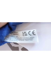 Etichetta in tessuto blu con istruzioni per la cura, numero articolo 43505 e dettagli del produttore, con marchi di certificazione UK e CE.