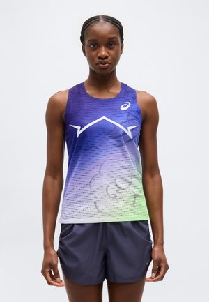 Športovec v bezrukávovom fialovom bežeckom tričku s bielym geometrickým vzorom a tmavomodrých krátkych nohaviciach, stojaci pred jednoduchým pozadím.