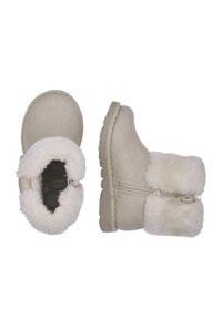 Botines beige con ribete de pelo sintético, parte superior texturizada, cremallera lateral y suela de goma con detalles antideslizantes. Interior suave para mayor comodidad.