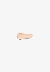 Swatch de base cremosa en tono beige claro con una textura suave, mostrada sobre un fondo claro, con una punta de aplicación redondeada y un borde afinado.