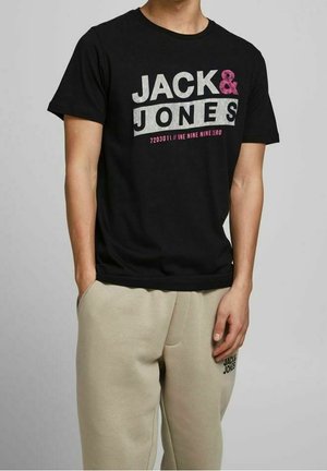 Černé bavlněné tričko s potiskem "JACK & JONES" v bílé a růžové barvě. Kolečkový výstřih, krátké rukávy, spárované se světle béžovými tepláky.