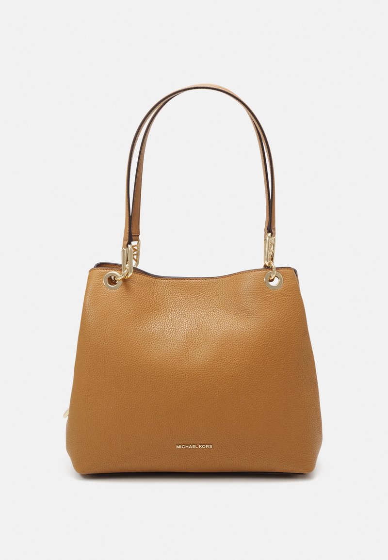 Sac à main en cuir fauve avec surface texturée, deux anses d'épaule, ferrures dorées et marquage discret en bas. Forme structurée.
