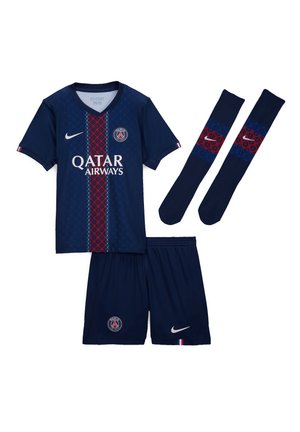Maillot de football bleu marine du Paris Saint-Germain avec maillot, short et chaussettes, mettant en avant des rayures à motifs rouges et bleus ainsi que des logos Nike.