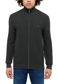 Tmavě zelená mikina na zip s vysokým límcem, žebrovanými manžetami a slim fit. Na hrudi se nachází malé logo a má jemnou texturu.