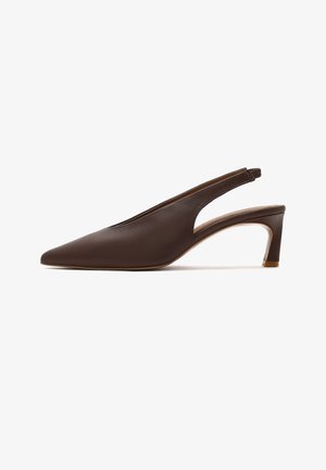 Brązowy skórzany but na obcasie typu kitten heel z odkrytą piętą, zamszowy, z noskiem w szpic i niskim, szerokim obcasem, minimalistyczny design na białym tle.
