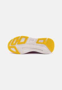 Shoe outsole featuring a white and yellow color scheme, textured grip patterns, and cutouts for flexibility with "Natural Rocker Technology" engraved.