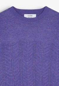 Lilla strikket sweater med ribbet crewnek. Kroppen har et tekstureret bølgemønster, der giver visuel dybde og interesse.
