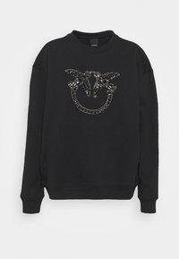 Felpa nera in tessuto morbido, con un ornamento decorativo di strass a forma di cerchio e ali sulla parte frontale.