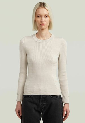 Pull en maille côtelée beige clair à manches longues et col rond. Présente une silhouette ajustée et des panneaux texturés sur le devant.