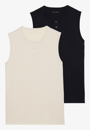Two sleeveless cotton tops: one beige with a buttoned placket, and one solid black. Both feature a round neckline and fitted design.