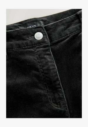 Czarne spodnie z korduroy z metalowym zapięciem, zamkiem błyskawicznym, bocznymi kieszeniami oraz teksturowanym materiałem z pionowymi prążkami. Widoczna metka marki.