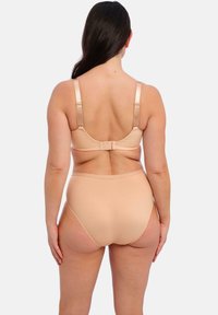 Ensemble de soutien-gorge beige clair et culotte taille haute, design sans coutures, bretelles réglables, fermeture avec crochet et œil à l'arrière, texture lisse.