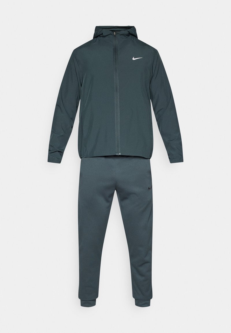 Chándal de Nike, que consiste en una chaqueta con capucha y pantalones ajustados. Está hecho de una tela gris oscuro con una textura suave y acentos de logo en blanco.