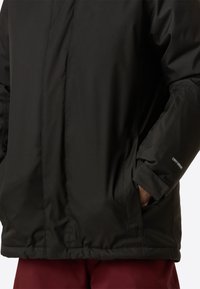 Giacca nera isolata con cerniera frontale, tasche laterali e logo "DRYVENT" sulla manica. Texture liscia con design strutturato.