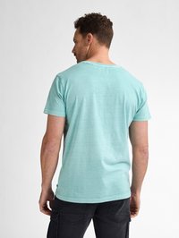 T-shirt di cotone blu chiaro con scollo rotondo, maniche corte e vestibilità rilassata. Presenta una texture liscia e una finitura morbida.