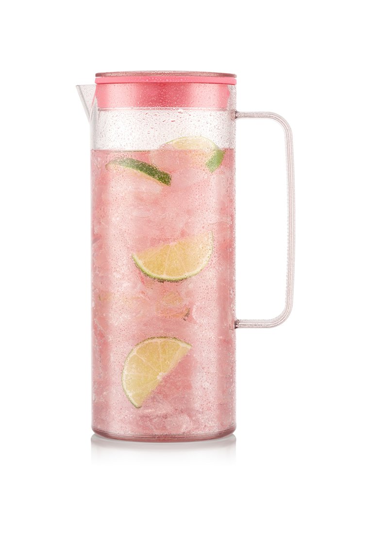 Jarra transparente con limonada rosa, cubitos de hielo y rodajas de lima, sellada con una tapa rosa y un asa transparente.